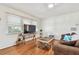 Cozy living room featuring hardwood floors, a large window, and a dark brown couch at 349 Shirley Ave, Belleair, FL 33756