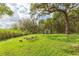 Sprawling backyard with mature trees and outdoor seating, creating a serene and private oasis at 36246 Peak St, Zephyrhills, FL 33541