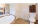 Bright bathroom with a soaking tub, toilet, and vanity with a towel rack, providing comfort and convenience at 36246 Peak St, Zephyrhills, FL 33541