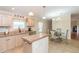 Well-appointed kitchen with a center island, adjacent to a dining area with a glass-top table and upholstered chairs at 36246 Peak St, Zephyrhills, FL 33541