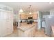 Bright kitchen with neutral cabinetry, an island, and modern appliances, adjacent to the laundry area at 36246 Peak St, Zephyrhills, FL 33541