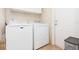 Bright laundry room features a side-by-side washer and dryer, storage cabinet, and easy access to the outside at 36246 Peak St, Zephyrhills, FL 33541