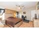 Comfortable bedroom featuring wooden floors, a ceiling fan, and a rustic wood accent wall at 36246 Peak St, Zephyrhills, FL 33541