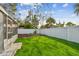 Lush backyard featuring manicured lawn, white fence, rock garden, and screened patio access at 3907 Elkcam Se Blvd, St Petersburg, FL 33705