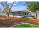 Backyard view of house featuring screened-in patio, shade trees, and a white vinyl privacy fence at 3907 Elkcam Se Blvd, St Petersburg, FL 33705
