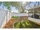 Backyard space featuring a privacy fence, decorative mulch, manicured lawn, and a screened lanai at 3907 Elkcam Se Blvd, St Petersburg, FL 33705