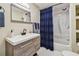 Bathroom showcasing a modern vanity, mirror, and shower/tub combo with a stylish navy shower curtain at 3907 Elkcam Se Blvd, St Petersburg, FL 33705