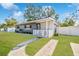 Charming home with a well-manicured lawn, mature shade trees, and a white picket fence at 3907 Elkcam Se Blvd, St Petersburg, FL 33705