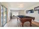 Pool table is the center piece of this game room with wood-look floors and modern fixtures at 3907 Elkcam Se Blvd, St Petersburg, FL 33705