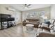 Cozy living room featuring wood-look flooring, plush seating, and a ceiling fan at 3907 Elkcam Se Blvd, St Petersburg, FL 33705