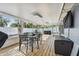 Stylish screened patio with a table, grill, fans, and plenty of space to relax and dine at 3907 Elkcam Se Blvd, St Petersburg, FL 33705