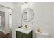 Modern bathroom with green vanity, round mirror, gold faucet and toilet at 3915 N Ola Ave, Tampa, FL 33603