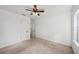 Carpeted bedroom featuring a ceiling fan, white walls, closet, and a window at 3915 N Ola Ave, Tampa, FL 33603