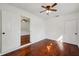 Cozy bedroom featuring a ceiling fan, white walls and hardwood floors at 3915 N Ola Ave, Tampa, FL 33603