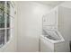 Functional laundry area with a stacked washer and dryer unit and a window for natural light at 3915 N Ola Ave, Tampa, FL 33603