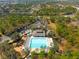 Aerial view of a community pool, playground and green trees at 4421 Larkenheath Dr, Spring Hill, FL 34609