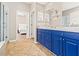 Bathroom showcasing dual sinks, blue cabinetry, and a view into the shower room at 4421 Larkenheath Dr, Spring Hill, FL 34609