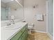 Bathroom featuring glass shower, green cabinets, tile floors and modern fixtures at 4421 Larkenheath Dr, Spring Hill, FL 34609