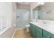 Bathroom featuring glass shower, green cabinets, tile floors and modern fixtures at 4421 Larkenheath Dr, Spring Hill, FL 34609