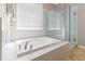Luxurious bathroom featuring a soaking tub, separate shower, and large window at 4421 Larkenheath Dr, Spring Hill, FL 34609