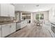 Bright kitchen featuring granite countertops, stainless steel appliances, and wood-look tile flooring at 4421 Larkenheath Dr, Spring Hill, FL 34609