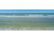 Scenic beach view with gentle waves and clear blue skies, perfect for relaxation and recreation at 4550 Plaza Way, St Pete Beach, FL 33706