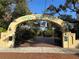 Mediterranean estate entrance with ornate wrought-iron gates and 'Vista Del Lago' sign, surrounded by mature landscaping at 5020 S Shore Crest Cir, Tampa, FL 33609