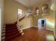 Elegant foyer with a grand staircase, crystal chandelier, stained glass window, and gleaming hardwood floors at 5020 S Shore Crest Cir, Tampa, FL 33609