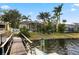 Beautiful backyard view featuring a screened lanai, tropical landscaping, and waterfront access from the private dock at 5229 Brighton Shore Dr, Apollo Beach, FL 33572