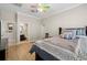 Cozy bedroom featuring laminate flooring, a ceiling fan, neutral walls, and a view into the en suite bath at 5229 Brighton Shore Dr, Apollo Beach, FL 33572