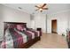 Spacious bedroom featuring wood floors, a ceiling fan, crown molding, and a comfortable bed with stylish bedding at 5229 Brighton Shore Dr, Apollo Beach, FL 33572