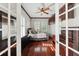 Bedroom featuring wood flooring, ceiling fan, and shuttered windows at 5229 Brighton Shore Dr, Apollo Beach, FL 33572