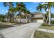 Beautiful home exterior featuring an attached garage and driveway surrounded by tropical landscaping at 5229 Brighton Shore Dr, Apollo Beach, FL 33572