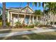 Inviting home exterior with a charming front porch, manicured lawn, and lush tropical landscaping at 5229 Brighton Shore Dr, Apollo Beach, FL 33572
