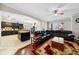 Open-concept living area with a kitchen view, hardwood floors, a ceiling fan, and a comfortable leather sofa at 5229 Brighton Shore Dr, Apollo Beach, FL 33572