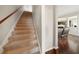Carpeted staircase leading to hardwood flooring, and a glimpse of the kitchen and living room at 5229 Brighton Shore Dr, Apollo Beach, FL 33572