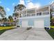 Two-story raised beach house with two-car garage, a spacious driveway and an open balcony at 6841 Oelsner St, New Port Richey, FL 34652