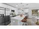 Modern kitchen featuring stainless steel appliances, a central island with seating and white cabinetry at 6841 Oelsner St, New Port Richey, FL 34652