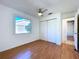 Bedroom featuring wood-look floors, a ceiling fan and a closet with sliding doors at 8600 Berkley Dr, Hudson, FL 34667