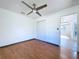 Bright bedroom with wood-look flooring, ceiling fan, and access to a view-filled bathroom at 8600 Berkley Dr, Hudson, FL 34667