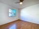 Well-lit bedroom with wood-look flooring, a ceiling fan, and a window at 8600 Berkley Dr, Hudson, FL 34667