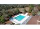 Aerial shot of a rectangular community pool surrounded by lounge chairs and tables in a wooded area at 8600 Berkley Dr, Hudson, FL 34667