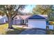 Charming single-story home featuring a two-car garage, stone accents, and a well-maintained front lawn at 8600 Berkley Dr, Hudson, FL 34667