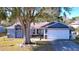 Attractive single-story home with a two-car garage, mature trees, and well-kept lawn at 8600 Berkley Dr, Hudson, FL 34667