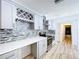 Charming kitchen features a wine rack, stainless steel appliances, quartz countertops, and a tiled backsplash at 8600 Berkley Dr, Hudson, FL 34667