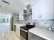 Modern kitchen with updated stainless steel appliances, quartz countertops, and stylish gray cabinetry at 8600 Berkley Dr, Hudson, FL 34667