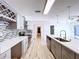 Bright updated kitchen offers stainless appliances, stone backsplash, an island with sink, and pendant lighting at 8600 Berkley Dr, Hudson, FL 34667