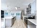 Open kitchen boasts stainless appliances, island with pendant lights, and views of living area with fireplace at 8600 Berkley Dr, Hudson, FL 34667