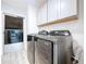Modern laundry room with stainless steel washer and dryer and overhead storage at 8600 Berkley Dr, Hudson, FL 34667