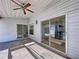 Covered outdoor patio with ceiling fan, featuring access to the pool area through sliding glass doors at 8600 Berkley Dr, Hudson, FL 34667